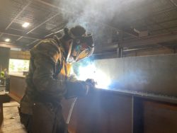 A worker from Flawless Steel Welding, a Denver-based small business